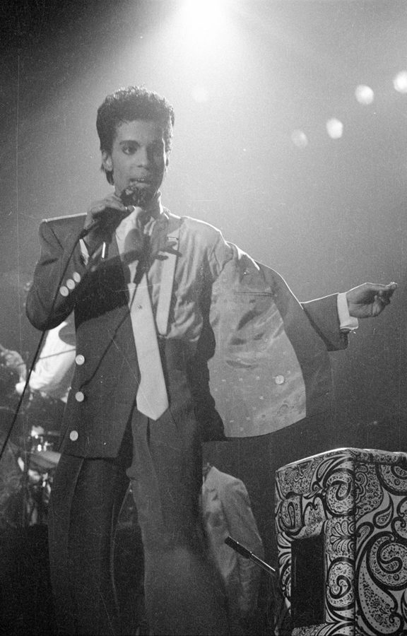 Prince no palco em Bruxelas, em 1986, sob um facho de luz.
